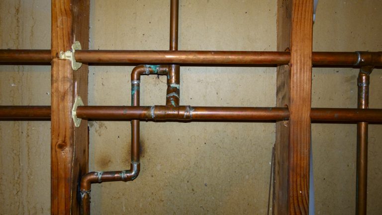 Turn Unsightly Exposed Plumbing Into an Attractive Storage Wall