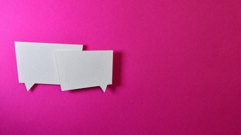 two white speech bubbles on a pink background