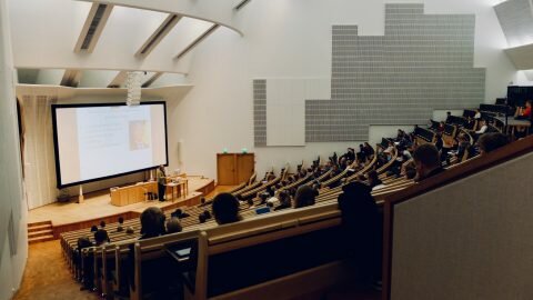 A modern lecture theatre full of students.